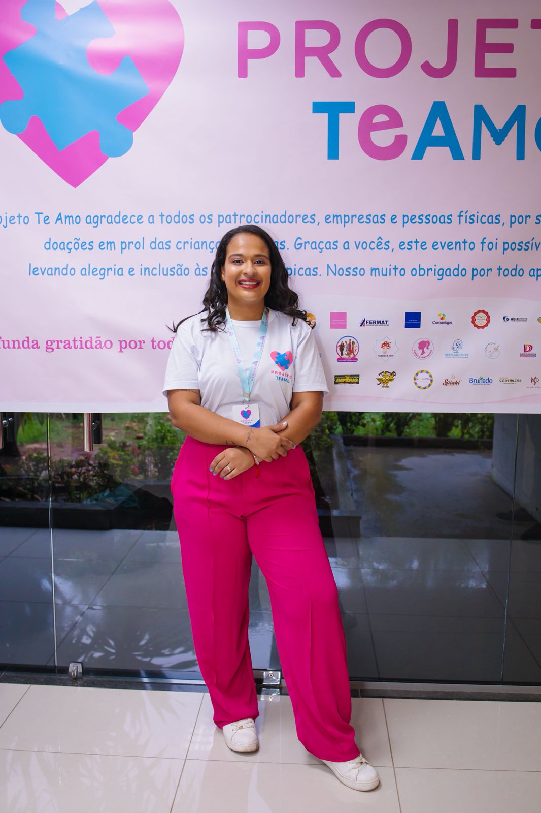 Foto da idealizadora do Projeto TEAMO em frente ao painel oficial